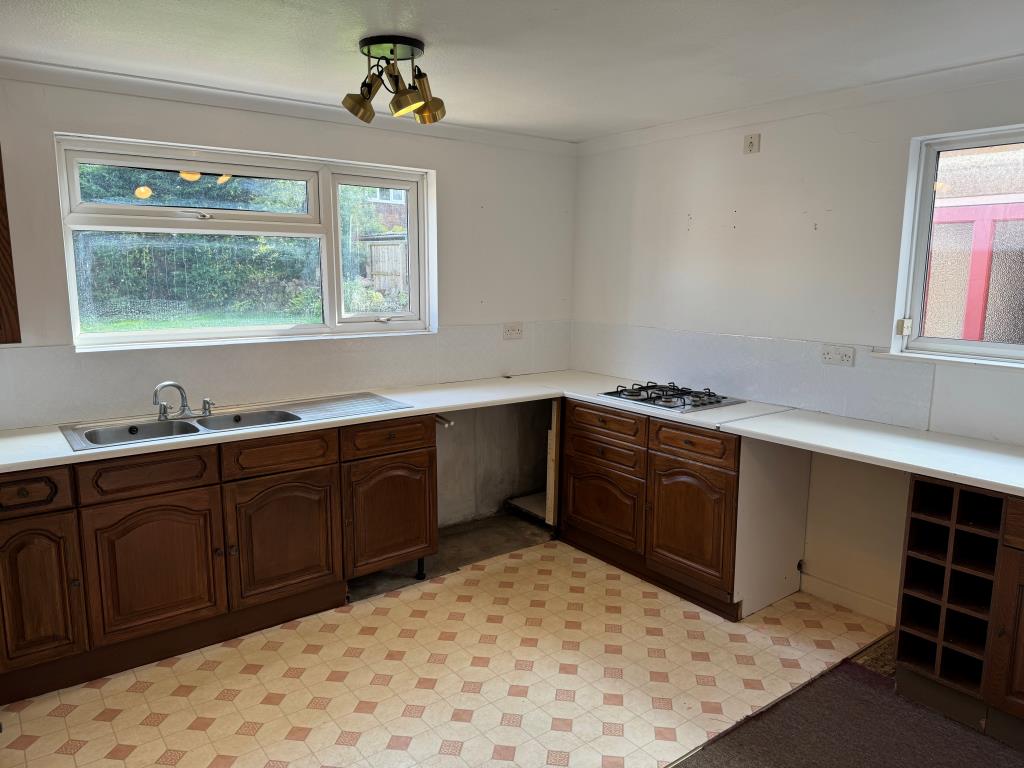 Lot: 154 - THREE-BEDROOM GROUND FLOOR APARTMENT FOR IMPROVEMENT WITH GARDENS AND GARAGE - Kitchen with units laminate flooring and view to garden